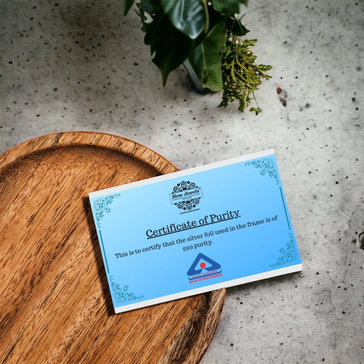 "Pure silver  Ganesh Laxmi frame's purity certificate placed on a table"